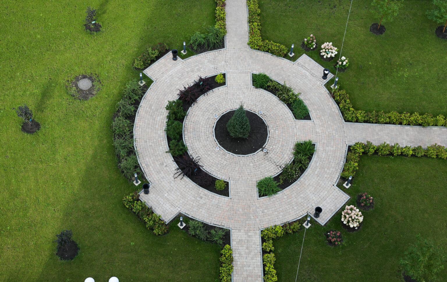 Luftbild einer neu angelegten Gartenanlage mit rundem Plattenweg, Beeten und Rasenflächen